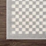 Close-up of the Gaiwan Cream Gray Washable Area Rug, featuring a checkerboard pattern in light gray and off-white. Corner