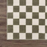 Close-up of the Kaysar Olive Green Checkered Washable Area Rug showing its texture and checkered pattern on wood floor. Corner