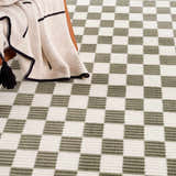 Close-up of the Kaysar Olive Green Checkered Washable Area Rug, showing its green and off-white checkered pattern. Styleshot
