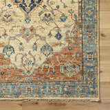 Bowlus Area Rug close-up. Hand-knotted wool rug with aqua, brick red, and ivory traditional pattern on wood floor. Corner