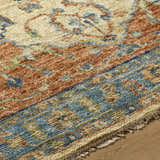 Close-up of the hand-knotted Bowlus Area Rug. Features aqua, brick red, and brown tones in a traditional pattern. Texture