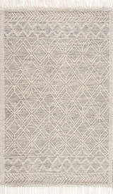 Close-up of the Ramsbury Wool Area Rug. Hand-woven rug with a geometric diamond pattern in black and ivory with fringed edges. Design-Rectangle-576
