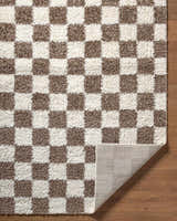 Close up of the Neftekamsk Area Rug. Brown and white checkerboard pattern, shaggy texture. Fold
