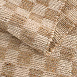 Close-up of the beige and tan Ionut Checkered Jute Area Rug, showing the woven texture and checkered pattern. Fold