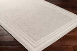 Close-up of the beige and gray Burradoo Bordered Area Rug showing the textured weave and striped border detail. Corner