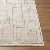Close-up of the Alma Machine Woven Elle Decor x LIVABLISS EDAL-2300 Area Rug in dark brown and taupe on wood floor. Front