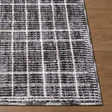 Close-up of the Odeon Elle Decor x LIVABLISS EDOD-2302 rug. Black, charcoal, and cream grid pattern on a soft, textured rug. Front