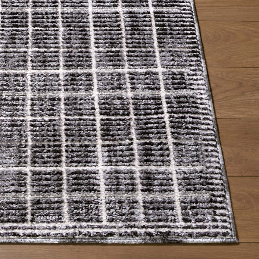 Close-up of the Odeon Elle Decor x LIVABLISS EDOD-2302 rug. Black, charcoal, and cream grid pattern on a soft, textured rug. Front