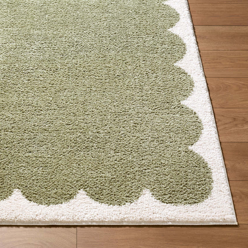 Close-up of Rivoli Elle Decor x LIVABLISS EDRV-2303 rug. Olive green rug with cream scalloped border on wood floor. Front
