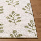 Close-up of Rivoli Elle Decor x LIVABLISS EDRV-2304 area rug with cream and olive botanical leaf pattern on wood floor. Front