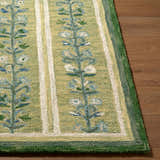 Close-up of the hand-tufted Callen Light Green Area Rug. Features a floral pattern, stripes, and a textured wool pile. Front