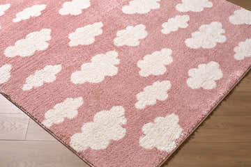 Close-up of the Dawo Pink Abstract rug. Features a pink background with a white cloud pattern and a soft, textured feel. Corner