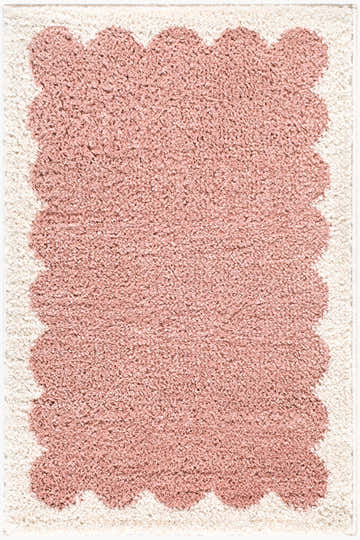 Close-up of the Hera Pink Border rug. The rug is ivory with a pink scalloped border and soft, plush texture. Design-Rectangle-2211