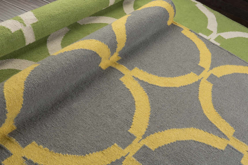Close-up of the Bloomer Area Rug, a hand-woven wool rug with a gray and mustard geometric pattern. Contemporary style. Styleshot