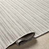 Close-up of the Greg Area Rug showing lambswool, multi brown, and smoke colors with a textured, machine-woven design. Fold