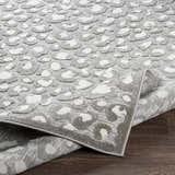 Close up of the Greensborough Performance Rug showing a gray and white animal print pattern and machine woven texture. Fold