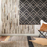 Room scene with Lyndoch Leather Patchwork Rug, leather wall art, and butterfly chair with woven leather pillow. Styleshot