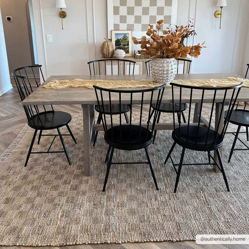 Farmhouse dining room with Ionut Checkered Jute Area Rug, wood table, black chairs, and neutral decor. Beige and tan rug. Roomscene-Rectangle