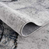 Close-up of the Fremantle Gray Marble Rug showing its cream, gray, and gold contemporary pattern and machine-woven texture. Fold