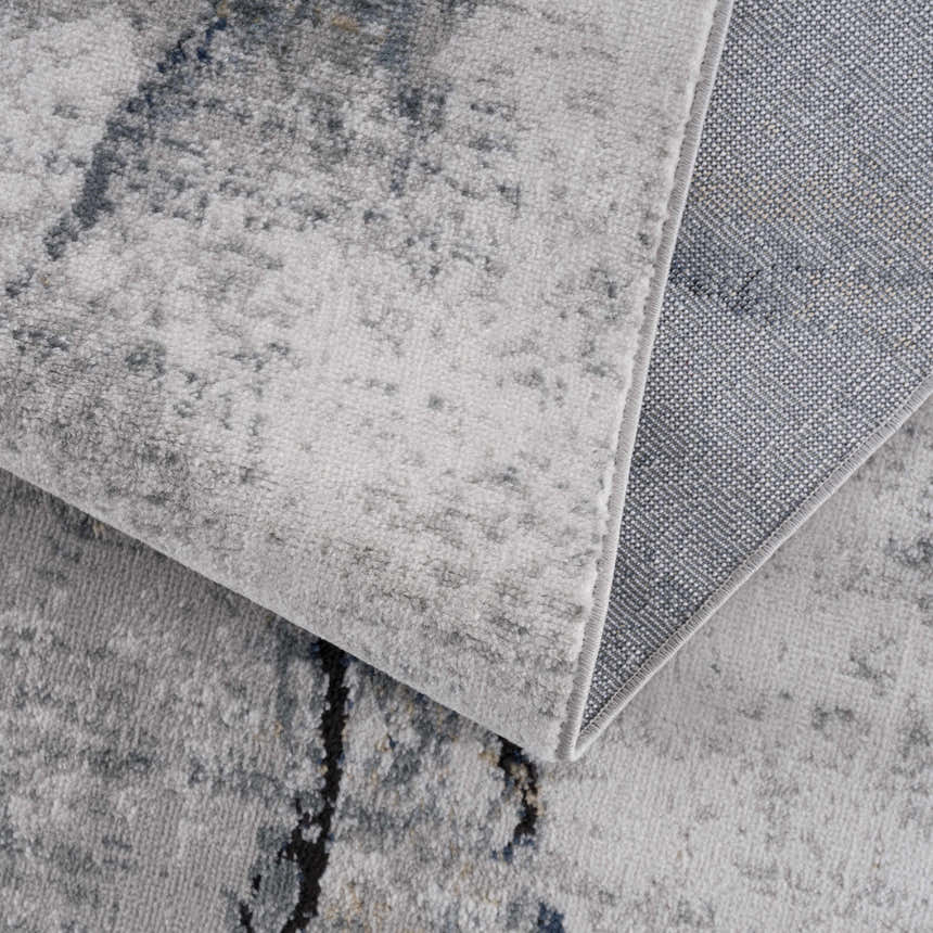 Close-up of the Fremantle Gray Marble Rug showing its cream, light gray, and dark gray abstract pattern and woven backing. Fold