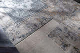 Close-up of Pinjarra Luxe Rug samples in charcoal, cream, and gray, showing contemporary designs and textures. Styleshot