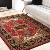Living room scene with a red, black, and orange Oriental style Malpas Area Rug under a light gray sofa. Roomscene-Rectangle