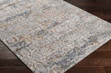 Close-up of the Marden Textured Luxe Area Rug showing brick red, camel, charcoal, and cream colors on a dark wood floor. Corner