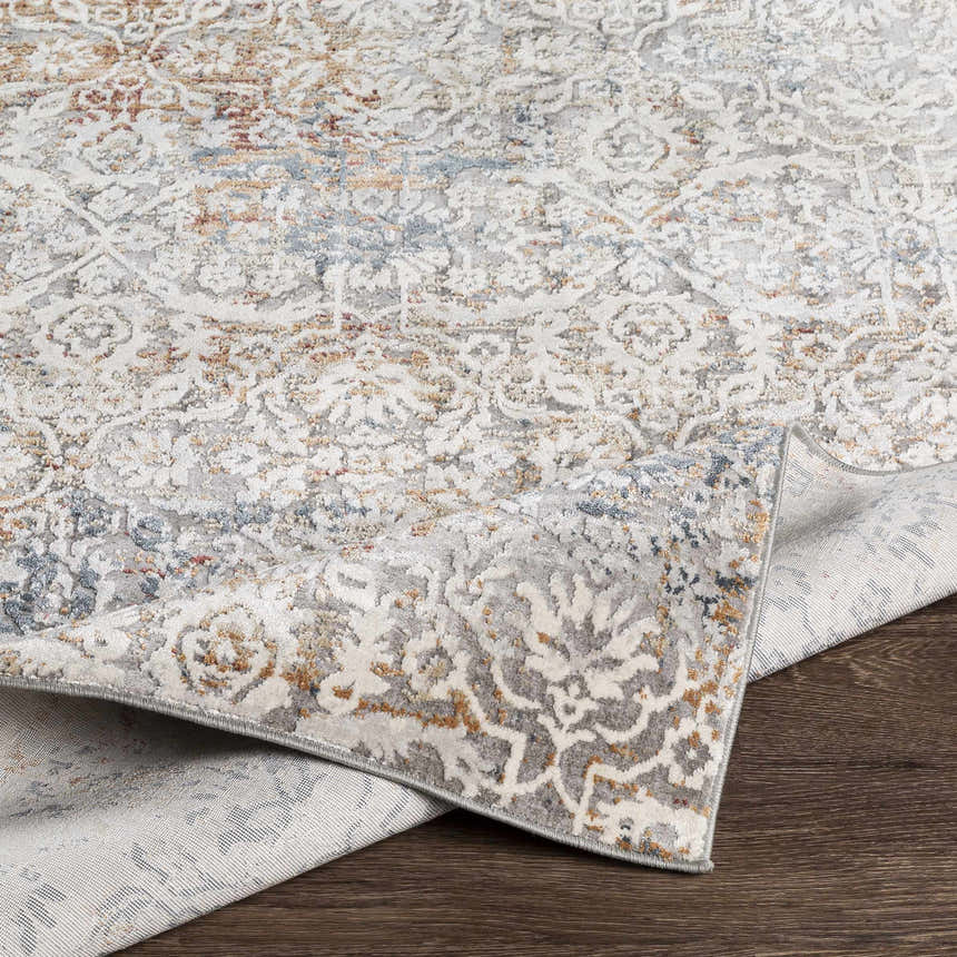 Close-up of the Marden Textured Luxe Area Rug showing its brick red, camel, and gray traditional pattern and textured weave. Fold