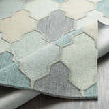 Close-up of the Monteview Sage&Teal Geometric Wool Rug, showcasing its pattern, texture, and colors like sage, teal, and gray. Fold