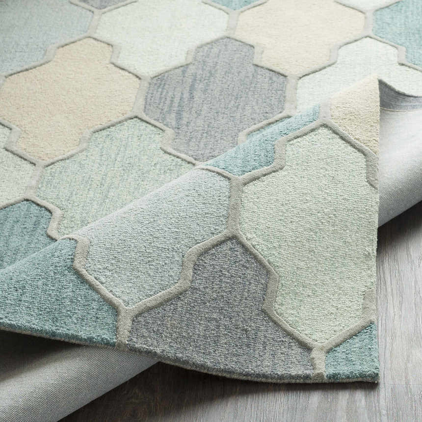 Close-up of the Monteview Sage&Teal Geometric Wool Rug, showcasing its pattern, texture, and colors like sage, teal, and gray. Fold