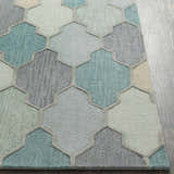 Close-up of Monteview Sage&Teal Geometric Wool Rug. Hand-tufted wool rug with geometric pattern in sage, teal, and gray hues. Front