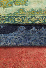 Close-up of the hand-tufted Gilbertsville Area Rug. Features a traditional pattern in dusty sage, teal, and red wool. Styleshot