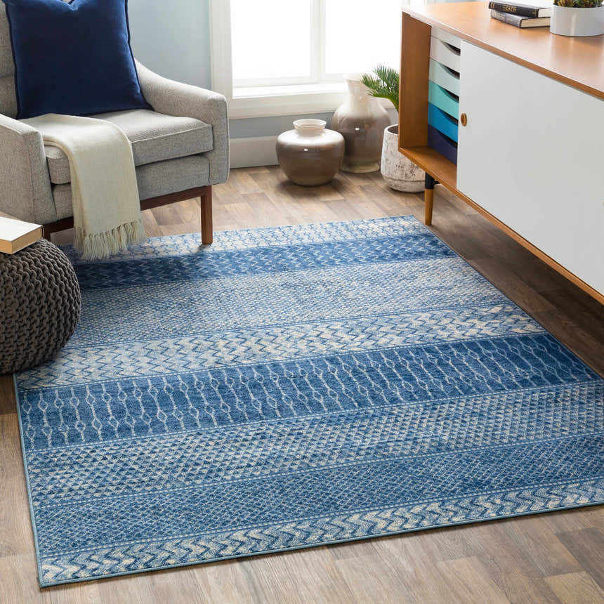 Living room scene with a blue and ivory Nampa Area Rug, gray chair, and mid-century modern cabinet. Roomscene-Rectangle
