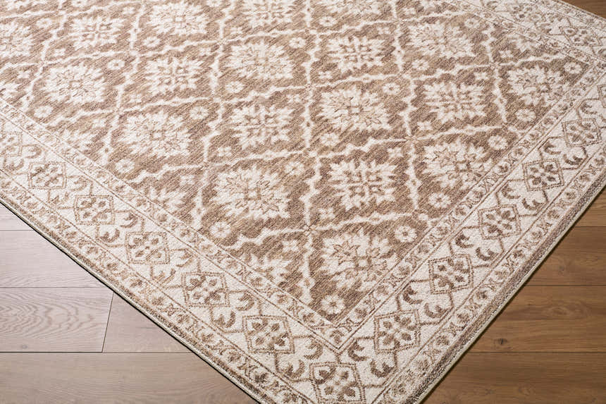 Close-up of the Aram Machine Woven Nabela Noor Home x LIVABLISS NBAR-2306 Area Rug. Brown and gray traditional pattern. Corner
