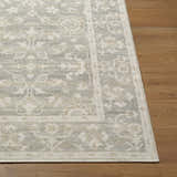 Close-up of Asha Machine Woven Nabela Noor Home rug. Farmhouse style rug in mustard, off-white, and sage on wood floor. Front