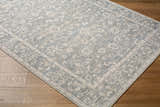Close-up of Asha Nabela Noor Home x LIVABLISS NBAS-2302 Area Rug. Sky blue, off-white traditional floral pattern. Corner
