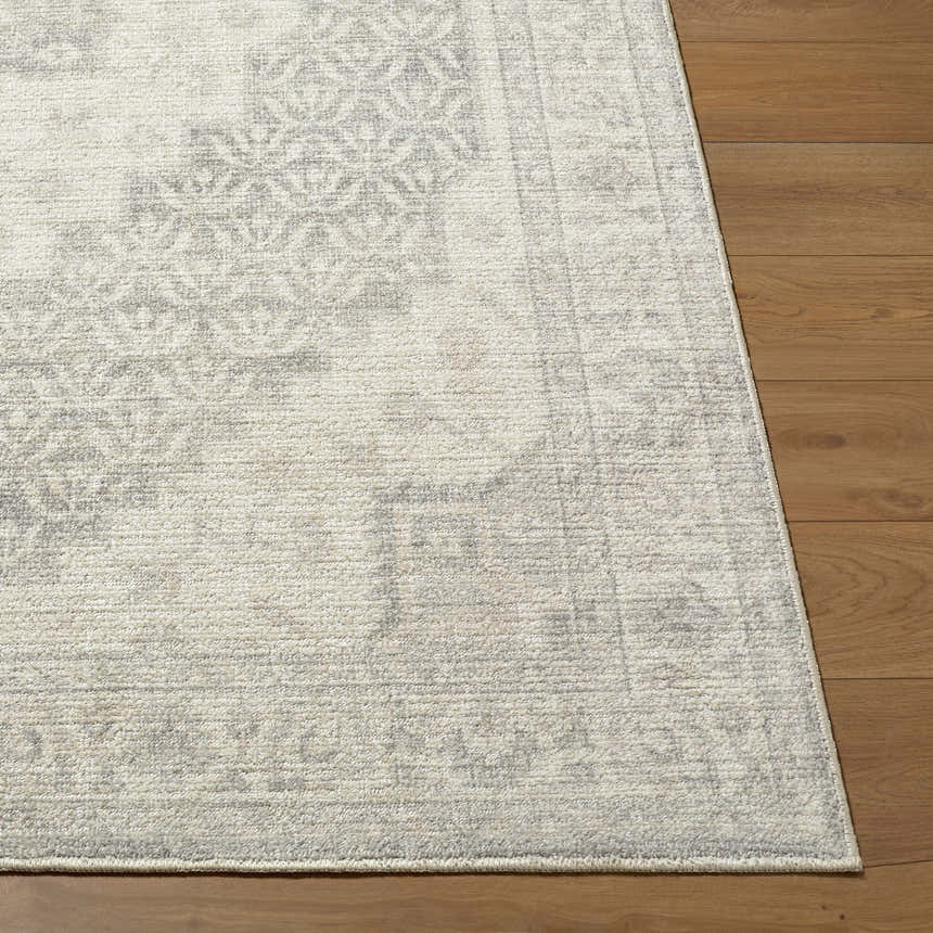 Close-up of Athiyo Nabela Noor Home x LIVABLISS rug. Beige rug with gray traditional pattern on wood floor. Front