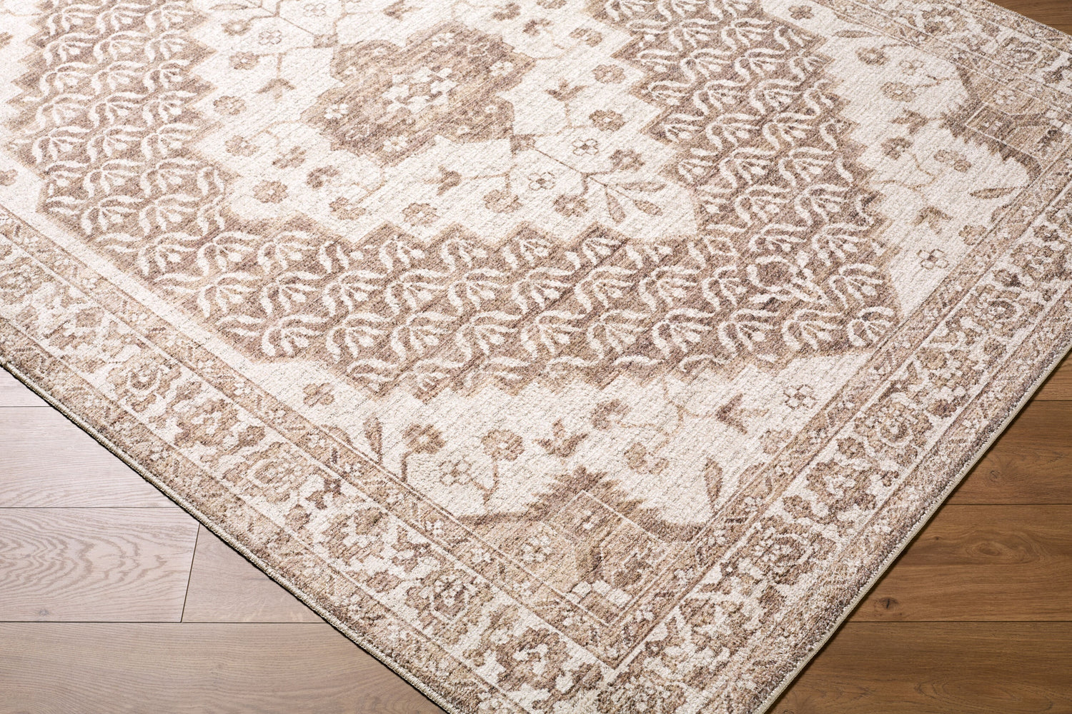 Close-up of the Athiyo Machine Woven Nabela Noor Home x LIVABLISS NBAT-2305 Area Rug, showing its brown traditional pattern and texture. Corner