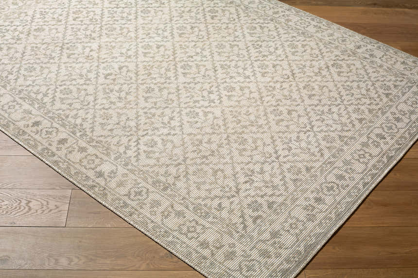 Close-up of the Maan Nabela Noor Home x LIVABLISS NBMA-2301 Area Rug. Gray and off-white farmhouse style rug with a traditional pattern. Corner