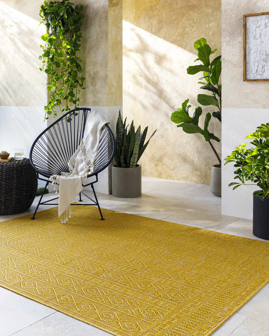 Bright mustard Nuela rug in a sunlit indoor patio with plants and modern chair. Roomscene-Rectangle