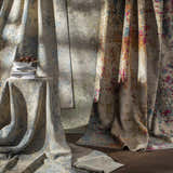 Abstract Greenhills Handmade Wool Area Rug in beige, blue, and pink hues styled with books and a vase. Styleshot