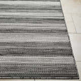Close-up of the Kris Black Area Rug showing its woven texture and horizontal stripes in beachhouse and dark gray. Front