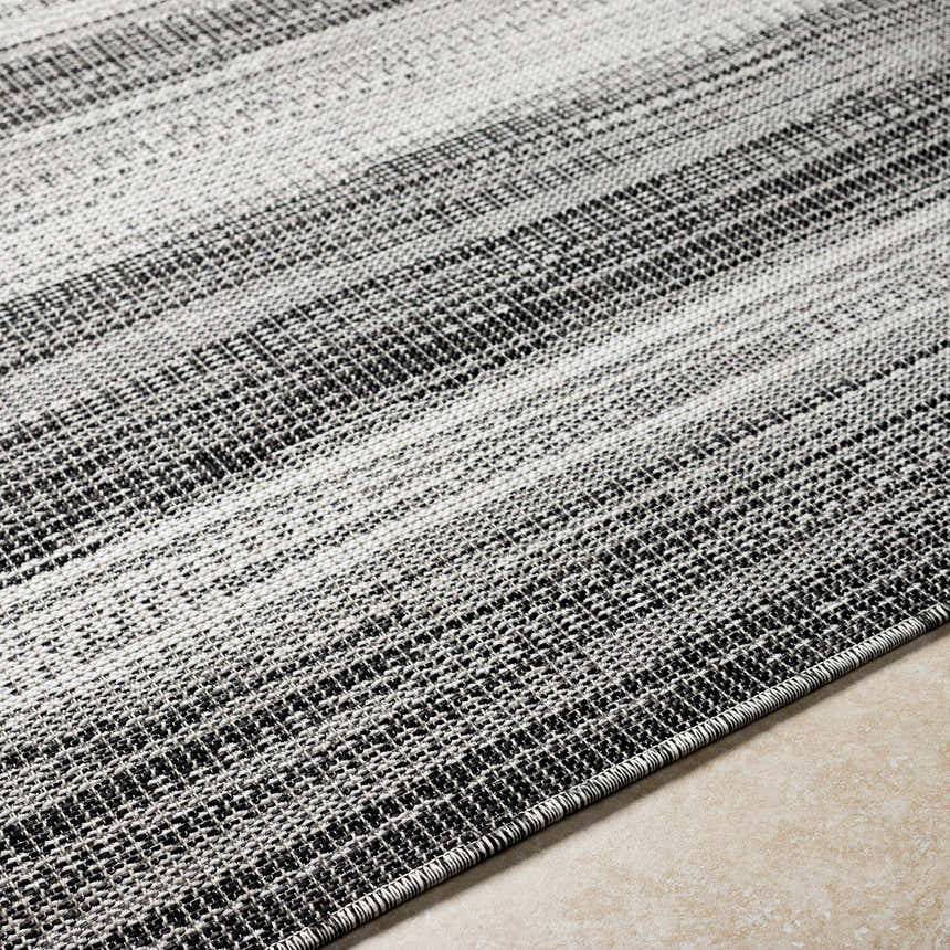 Close-up of Kris Black Area Rug showing woven texture and beachhouse and dark gray stripes. Texture