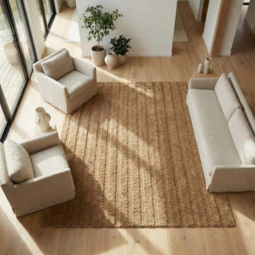 Neutral living room with a tan Konani Washable Area Rug, sofa, and armchairs. Modern, bright, and airy. Roomscene-Rectangle