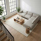 Modern living room with ivory Kanuha Washable Area Rug, light wood floors, sectional sofa, and large windows. Roomscene-Rectangle