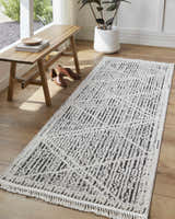 Entryway with wood bench and Luuk Area Rug, a dark brown and ivory geometric runner with tassels. Roomscene-Runner