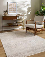 Living room scene with a beige Dalila Area Rug, wood console table, and neutral armchair. Roomscene-Rectangle
