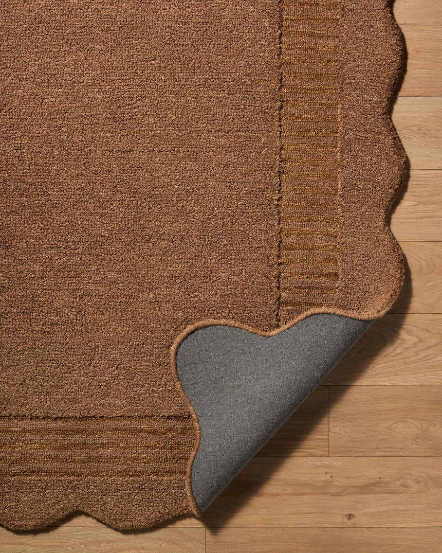 Close-up of the brown Gurib Border Modern Hand Tufted Wool Area Rug showing texture, backing, and scalloped edge. Fold
