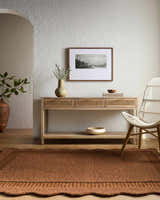 Entryway with a Gurib Border Modern wool rug, console table, textured walls, and a white chair. Roomscene-Rectangle