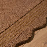 Close-up of the hand-tufted Gurib Border Modern Wool Area Rug. Features a textured pile and linear border detail. Texture